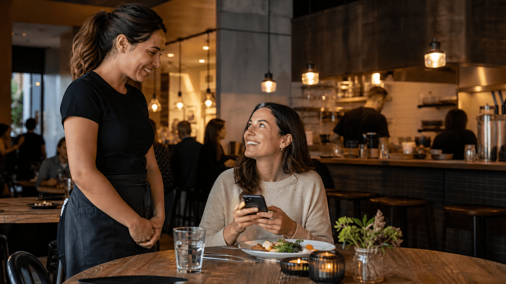 A restaurant guest holding a phone after a positive table-side conversation with a server